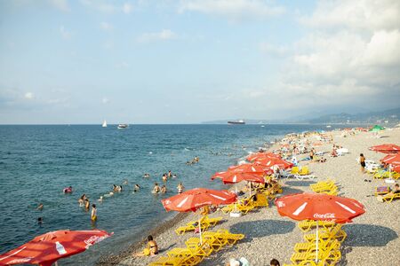 Batumi, Georgia August 2018: Coca Cola Umbrella On The Black Sea Beach with cloud sky on the backgroundのeditorial素材