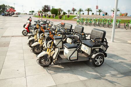 batumi, Georgia August 2018 Electric tricycle scooters for rent on Batumi New Boulevard. View of Batumi Boulevard Summerのeditorial素材