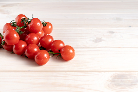 Cherry tomatoes on the white wooden table. Juicy ripe vegetables. Healthy eating. vegetarian foodの写真素材
