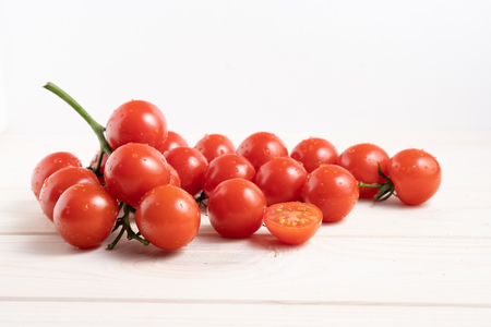 Cherry tomatoes on the white wooden table. Juicy ripe vegetables. Healthy eating. vegetarian foodの写真素材