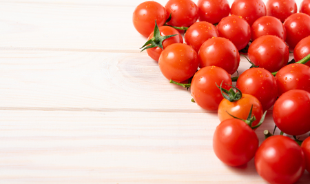 Cherry tomatoes on the white wooden table. Juicy ripe vegetables. Healthy eating. vegetarian foodの写真素材