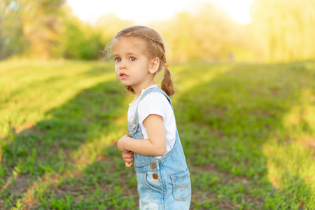 The little girl is scared, lost in the park. summer season.の写真素材