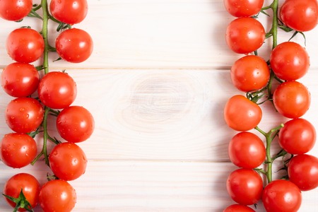 Cherry tomatoes on the white wooden table. Juicy ripe vegetables. Healthy eating. vegetarian foodの写真素材