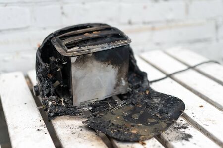 Burning toaster. Toaster with two slices of toast caught on fire over white background. Danger of careless handling of electrical appliances. Fireの写真素材