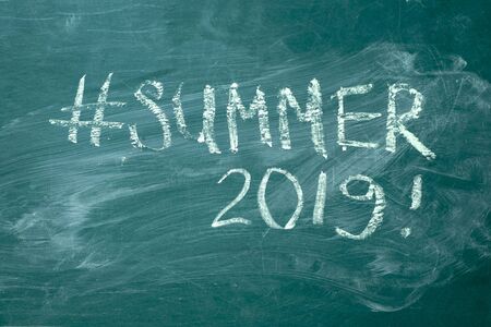 Summer hashtag it handwritten with white chalk on a green blackboard.の写真素材