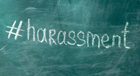 Harassment hashtag drawn in chalk on a blackboard. The concept of the inadmissibility of sexual harassmentの写真素材