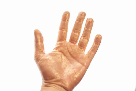 Human hand painted gold paint isolated on white background.の写真素材