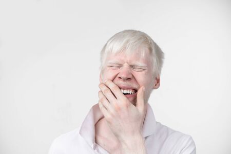 portrait of an albino man in  studio dressed t-shirt isolated on a white background. abnormal deviations. unusual appearance. skin abnormalityの写真素材