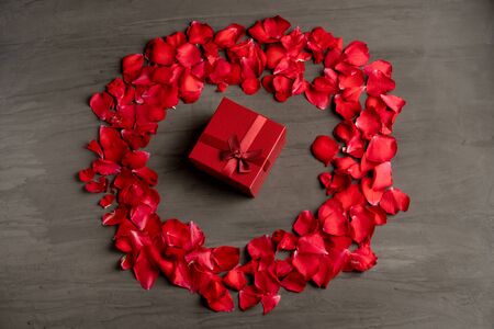 A round  frame made of rose petals on a dark cement table. Festive background is suitable for any holiday.の写真素材