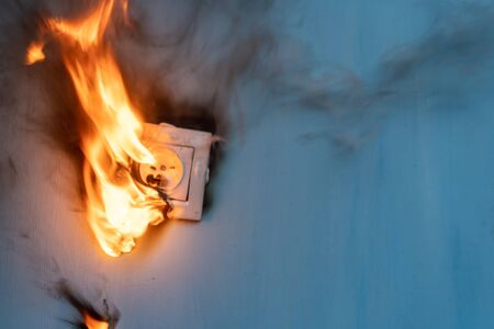 Apartment fire is caused by electrical outlet faults. Burnt and damaged electric plug socket from overload short circuit.の写真素材