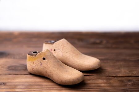Leather samples for shoes and wooden shoe last on dark wooden table. Designer furniture clothes....