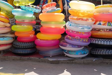 Many inflatable multi colored circles sold on market near the sea on vacation.