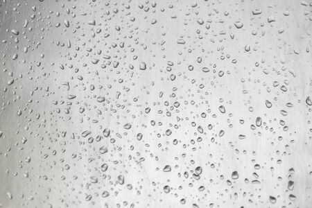 Water drops on window glass surface with blured nature background. Abstract weather conceptの写真素材