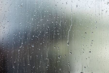 Water drops on window glass surface with blured nature background. Abstract weather conceptの写真素材