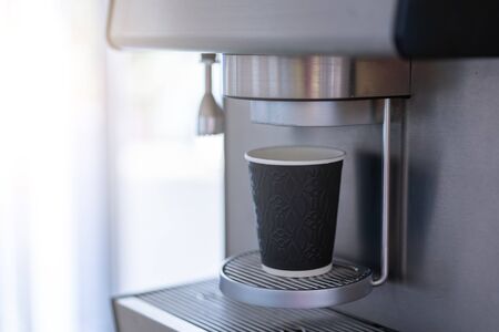 Coffee machine with paper cup and free space on the left For text. Professional machine for making coffee drinks.の写真素材