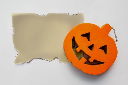 Halloween pumpkin with a burnt paper on a white backgroundの写真素材