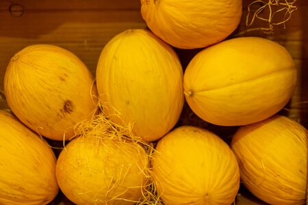Juicy beautiful yellow melon lies in a cardboard box on the shelves of the store. Close upの写真素材