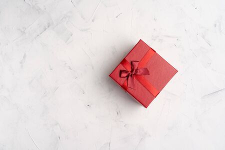 Red square holiday gift box against a white background New Year Valentine's Day birthday  present. minimalism.の写真素材