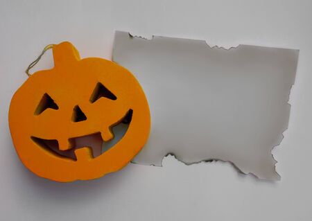 Halloween pumpkin with a burnt paper on a white backgroundの写真素材