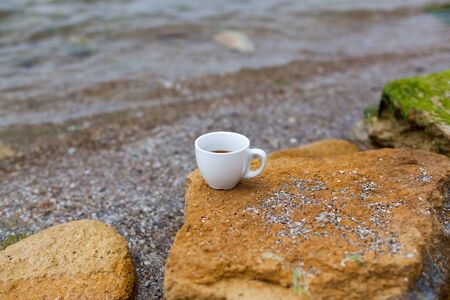 White mug, mock up, empty space for artwork, text, standing on wood plank, turquoise sea, clear blue sky, horizon, sunlight, nature.の写真素材