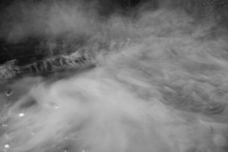 Thick white smoke on a background of black ceramic tiles. Dry ice tobaccoの写真素材