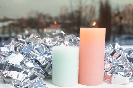 winter decor on windowsill with two candle and silver foil.の写真素材