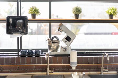 Disassembled multifunctional food processor in the kitchen by the window. A food processor stands on a window in a large bright kitchen without people.の写真素材