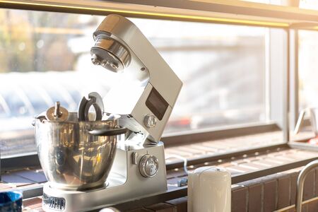Disassembled multifunctional food processor in the kitchen by the window. A food processor stands on a window in a large bright kitchen without people.の写真素材