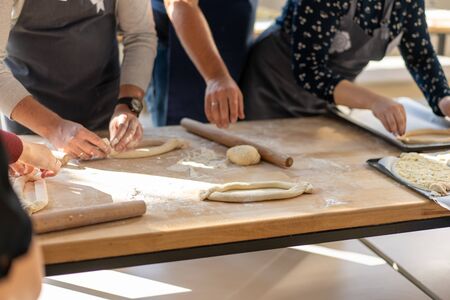 Culinary master class. Closeup of people hands preparing khachapuri. Traditional georgian cheese bread. Georgian food. Big unrecognizable family cooking hands close upの写真素材