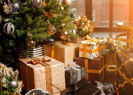 Close-up of a Christmas tree decorated with gold balls. Under the Christmas tree a large number of Christmas gifts. Christmas holiday concept. A huge number of gift boxes under Holiday backgroundの写真素材