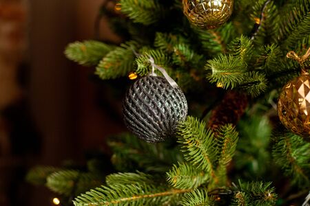 Close-up of a Christmas tree decorated with gold balls and blue bows. Christmas holiday concept. Free space for textの写真素材