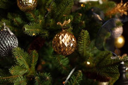 Close-up of a Christmas tree decorated with gold balls and blue bows. Christmas holiday concept. Free space for textの写真素材