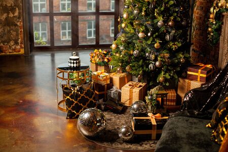 Close-up of a Christmas tree decorated with gold balls. Under the Christmas tree a large number of Christmas gifts. Christmas holiday concept. A huge number of gift boxes under Holiday backgroundの写真素材