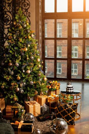 Close-up of a Christmas tree decorated with gold balls. Under the Christmas tree a large number of Christmas gifts. Christmas holiday concept. A huge number of gift boxes under Holiday backgroundの写真素材