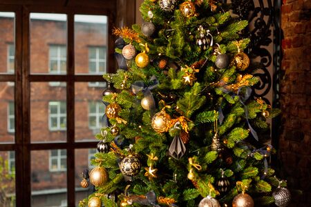 Close-up of a Christmas tree decorated with gold balls and blue bows. Christmas holiday concept. Free space for textの写真素材