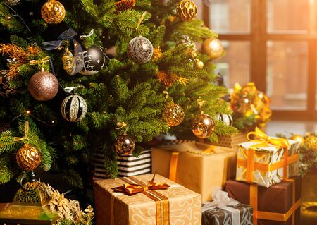 Close-up of a Christmas tree decorated with gold balls. Under the Christmas tree a large number of Christmas gifts. Christmas holiday concept. A huge number of gift boxes under Holiday backgroundの写真素材