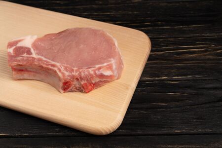 Top view of one pieces raw pork chop steaks on a cutting board. Wooden table.の写真素材