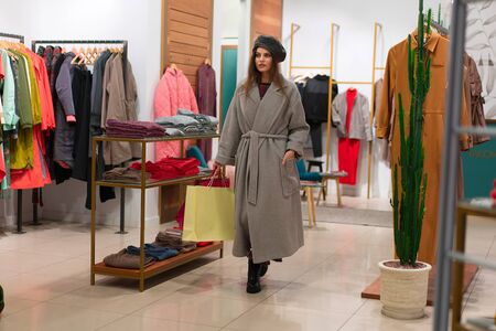 One caucasian women in a fashion boutique choose dress.  A professional stylist helps customers choose clothes. Season holiday shopping discounts sale European girl walk shopping mall. Lifestyle の写真素材