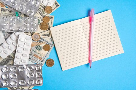 pills empty blisters for drugs individual syringe and money lie on a blue background Expensive medicine health insurance concept. Expensive treatment of diseases. Budget for medical expenses. Notebookの写真素材