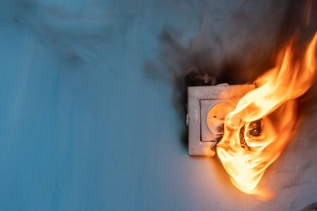 Apartment fire is caused by electrical outlet faults. Burnt and damaged electric plug socket from overload short circuit. の写真素材