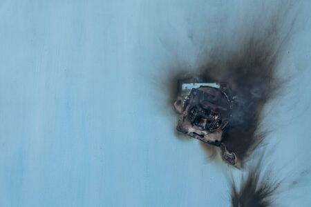 Apartment fire is caused by electrical outlet faults. Burnt and damaged electric plug socket from overload short circuit.の写真素材