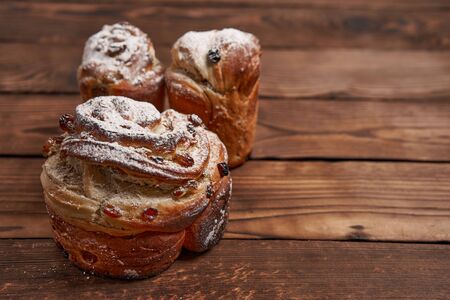 Traditional easter cake Kraffin stands on wooden table against a dark background. Spring holiday...