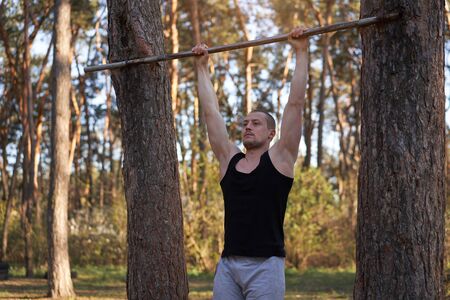 Handsome caucasian men pull-up outdoor workout cross training morning Pumping arm exercising sports...
