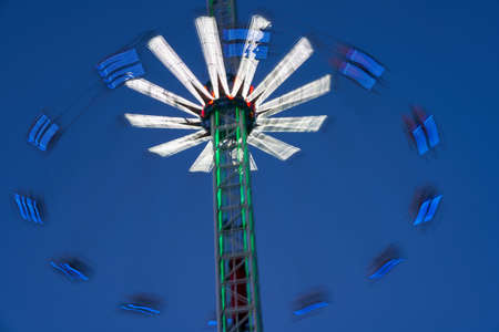 Amusement park blurred effect. Abstract illuminated background Spinning defocused carnival carousel long exposure shootingの写真素材