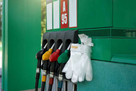 Coronavirus, covid-19 pandemic protective glove gas station gun. Epidemy protection. Personal protective equipment. self service Fuel station Stop virus.の写真素材