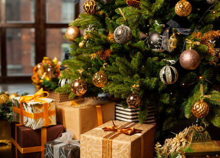 Christmas tree decorated with gold balls. Under the Christmas tree a large number of Christmas gifts. Christmas holiday concept.の写真素材