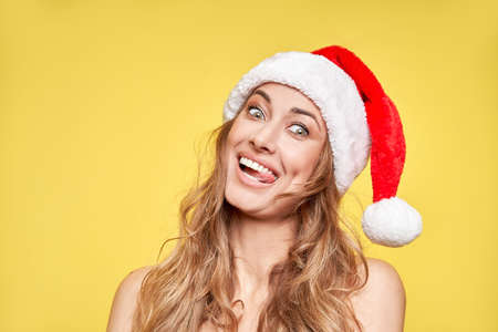 Woman christmas Santa Hat yellow studio background Beautiful caucasian female curly hair portrait...