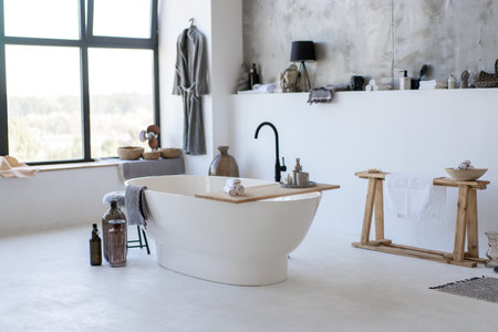 Modern vintage white bathroom near big window with many accessoriesの写真素材