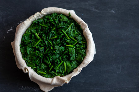 raw spinach pie preparation Standing wooden table background Copy space for textの写真素材
