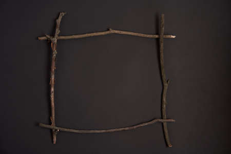 Walloween background Border square frame made wooden dry branch stick Placed center on black paper backgroundの写真素材